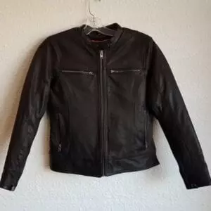 Leather jacket with zipper pockets hanging on wall