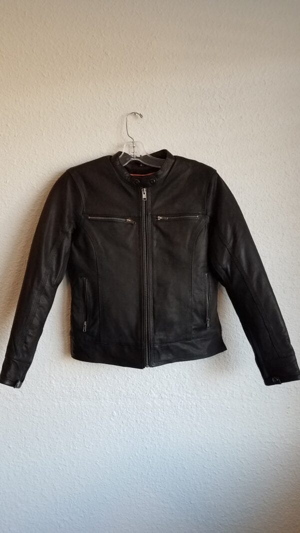 Leather jacket with zipper pockets hanging on wall