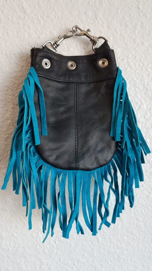 Black waste bag with blue fringe tassels